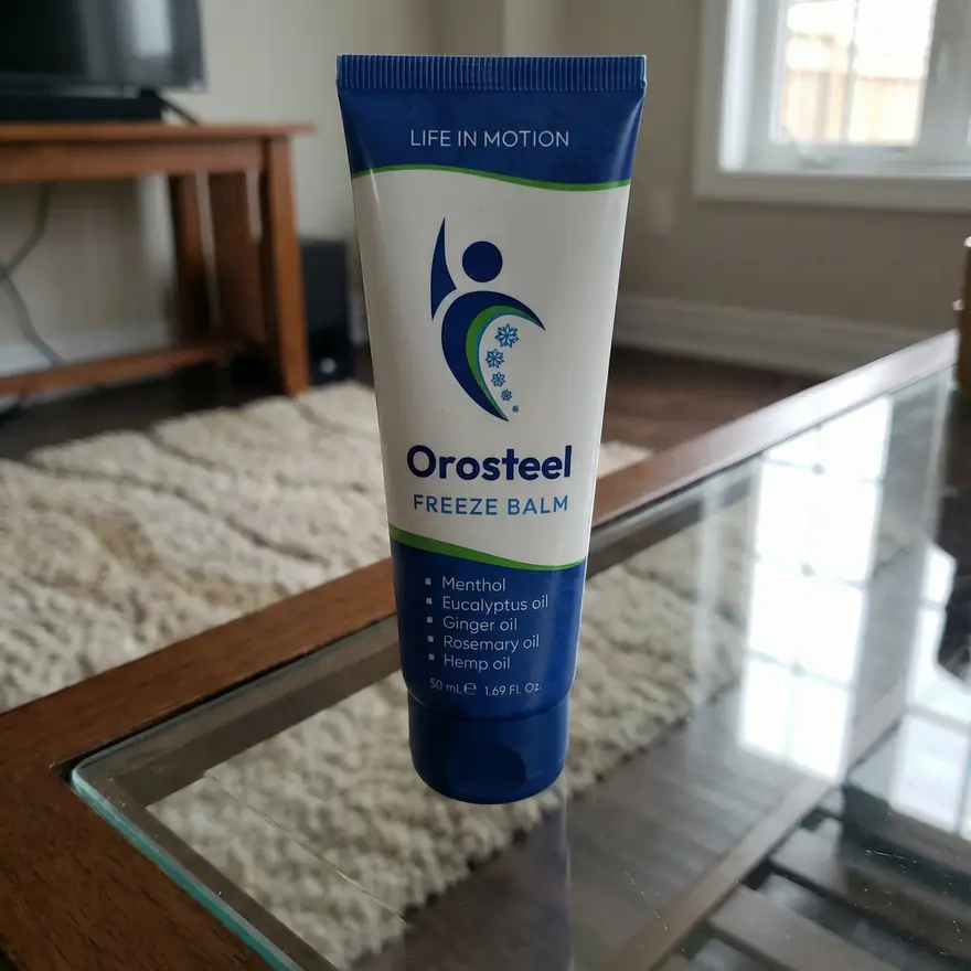 Tuba Orosteel Freeze Balm 50 ml na skleněném konferenčním stolku